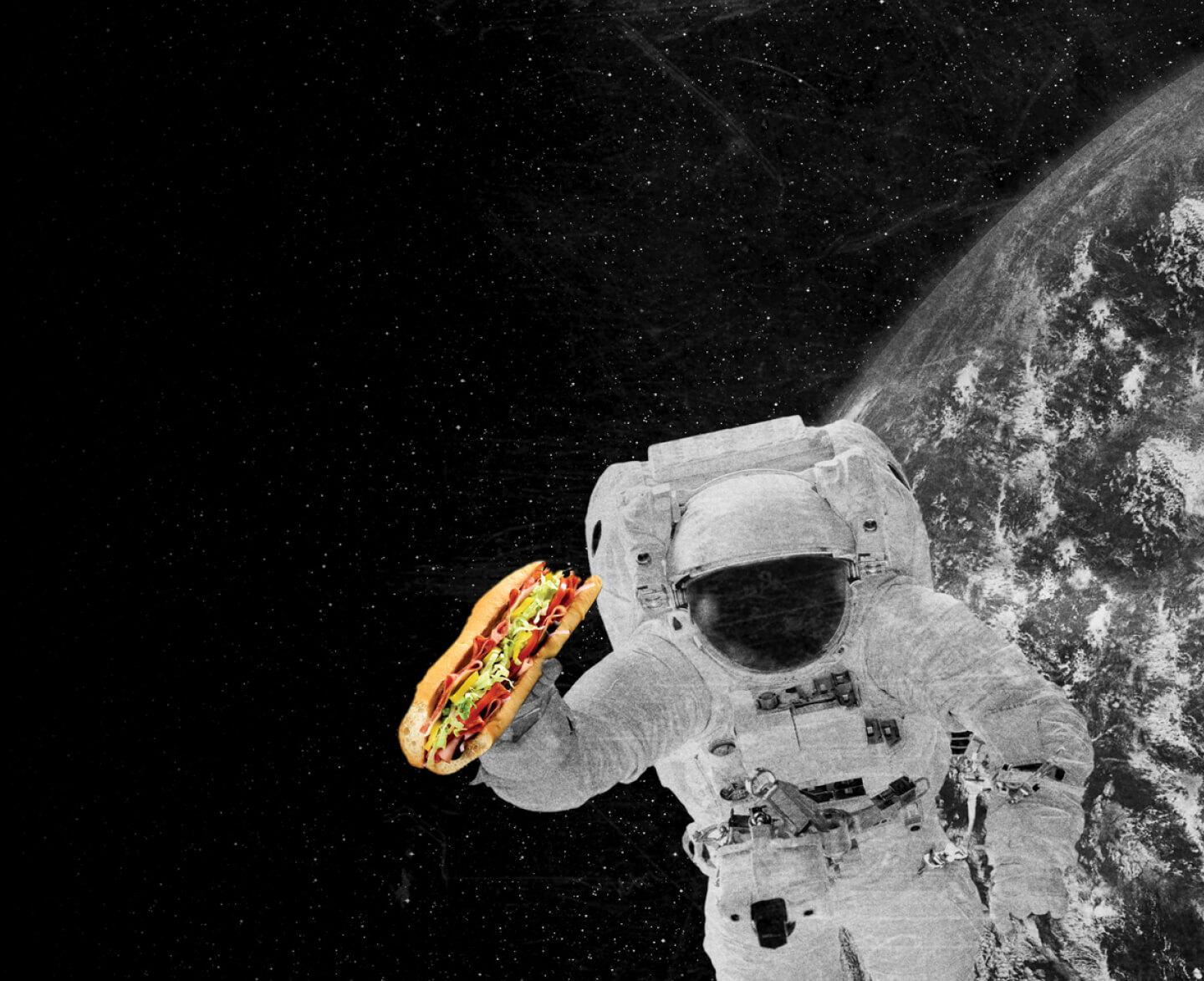 An astronaut in space eating a Quiznos sub